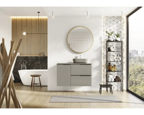 Lichte badkamer met bad, wastafel, spiegel en rek