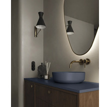 Moderne badkamer met waskom, wandkraan, verlichte spiegel en wandlamp.