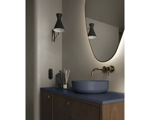 Moderne badkamer met waskom, wandkraan, verlichte spiegel en wandlamp.