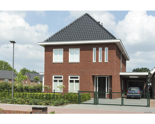 Vrijstaand huis met bakstenen gevel, dakpannen en carport