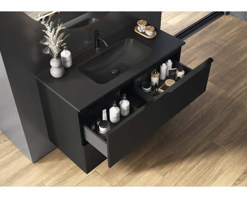 Badkamer met zwarte wastafelonderkast, open lade en verzorgingsproducten