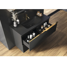 Zwarte wastafel met open lade, kraan en wasbak