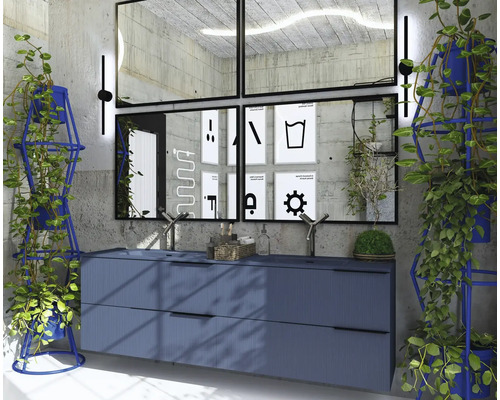 Badkamer met wastafel, spiegels, planten en decoratieve posters