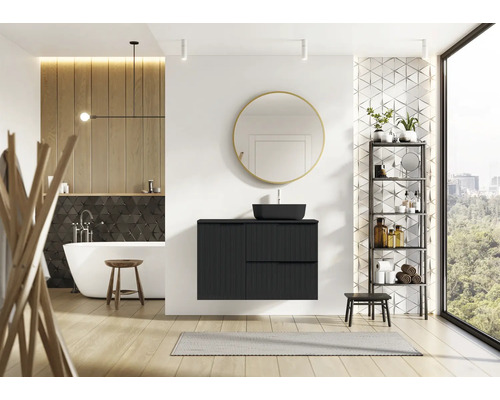 Moderne badkamer met zwart wastafelmeubel, spiegel, bad en plank.