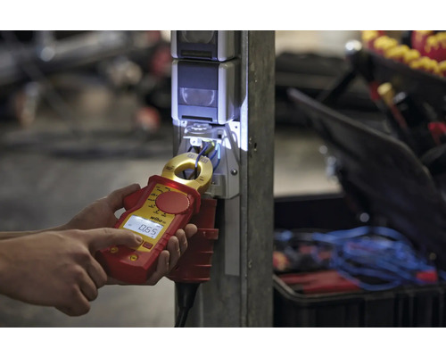 Persoon meet stroomsterkte met een Wiha stroommeter op een stopcontact