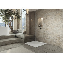 Moderne badkamer met douche, bad, zithoek en natuurstenen muur