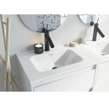 Moderne badkamer wastafel met kraan, spiegel en decoratie.