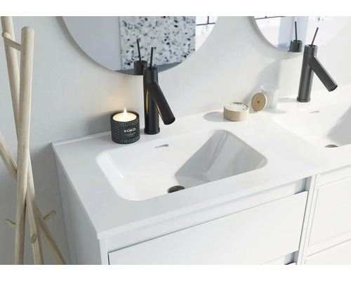 Moderne badkamer wastafel met kraan, spiegel en decoratie.