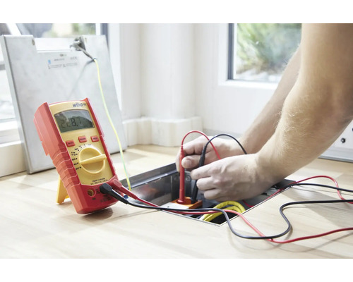 Elektricien meet spanning met een digitale multimeter.