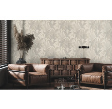 Woonkamer met behang met plantmotief, fauteuils en houten dressoir