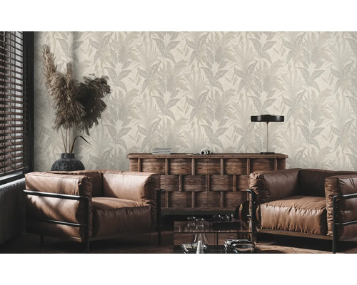 Woonkamer met behang met plantmotief, fauteuils en houten dressoir