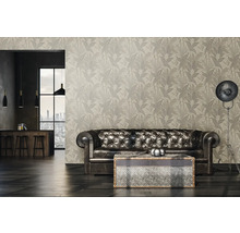 Woonkamer met patroonbehang, leren bank en staande lamp