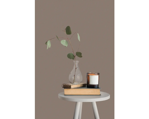 Decoratieve scène met kaars, vaas met planten en boeken op een bijzettafel