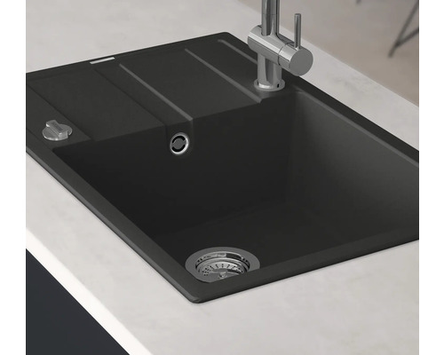Zwarte spoelbak met afdruiprek en kraan op een aanrecht