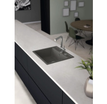 Keukenscène met spoelbak en kraan op een aanrecht.