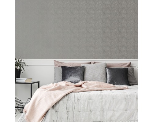 Slaapkamer met grijs structuurbehang op de muur.