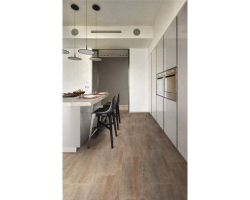 Lichte kamer met houten vloer, toonbank en kitchenette.
