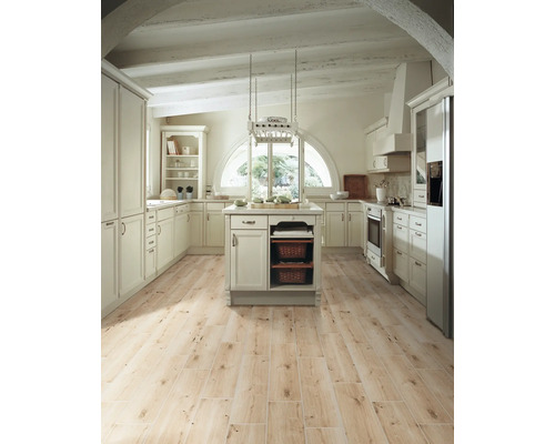 Lichte landelijke keuken met kookeiland, inbouwkasten en houten vloer.