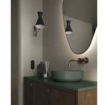 Badkamer met wastafel, spiegel, wandlamp en houten onderkast