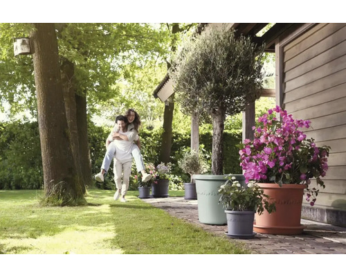 Tuinscene met man en vrouw die elkaar op de rug dragen, evenals diverse bloemen in bloempotten