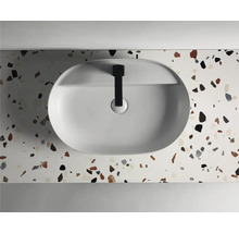 Opzetwastafel op een plaat met terrazzo-patroon en zwarte kraan