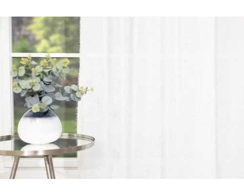 Eucalyptus in vaas op bijzettafel voor raam met gordijn