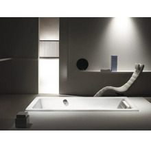 Badkamer met bad, ligstoel en minimalistisch design