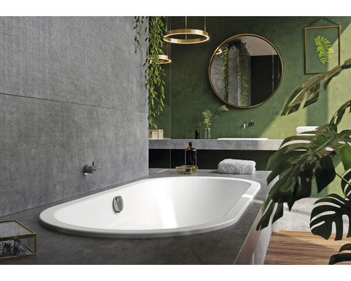 Badkamer met ligbad, wastafel, spiegel en planten voor een natuurlijke sfeer