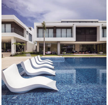 Zwembad met ligstoelen en moderne woonhuizen op de achtergrond