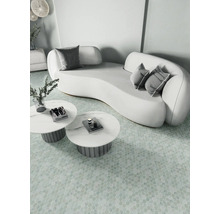 Lichte scène met een gebogen bank, kussens en ronde tafels op een gemusterde vloer