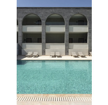 Zwembad met ligstoelen voor een gebouw met bogen