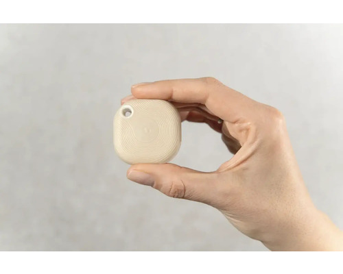 Hand houdt een tracker vast met een gat voor een sleutelhanger