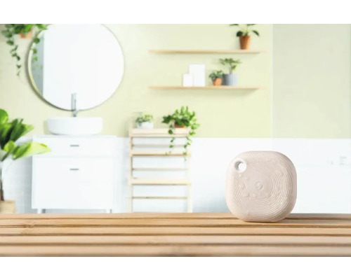 Slimme luchtverfrisser op houten tafel met badkamerachtergrond