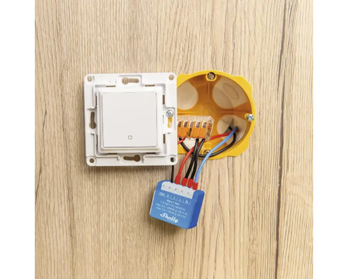 Installatie van een smarthome-lichtschakelaar met Shelly-logo in een inbouwdoos