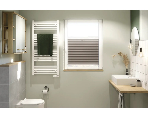 Lichte badkamer met wastafel, spiegel, radiator en raamjaloezie.