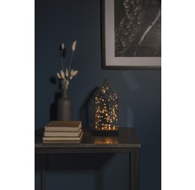 Decoratieve opstelling met LED-lamp, vaas, boeken en ingelijste afbeelding op een tafel