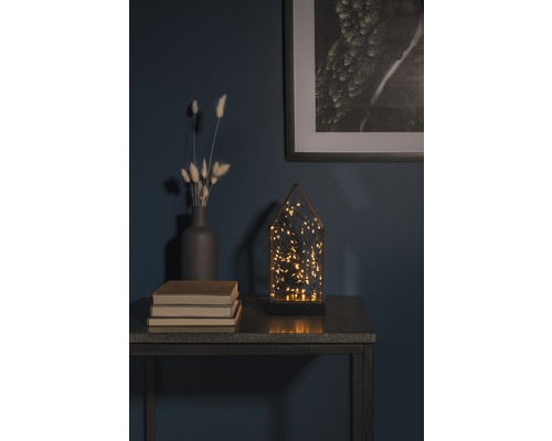 Decoratieve opstelling met LED-lamp, vaas, boeken en ingelijste afbeelding op een tafel