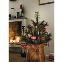 Versierde kerstboom in koperkleurige pot in woonkamerscène