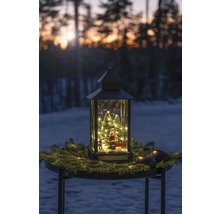 Decoratieve lantaarn met kerstman, kerstbomen en verlichting op een tafel