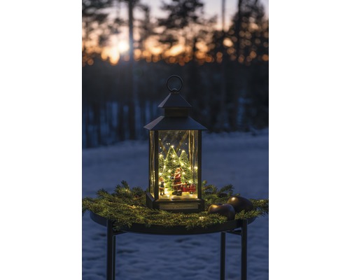 Decoratieve lantaarn met kerstman, kerstbomen en verlichting op een tafel