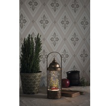 Decoratieve sneeuwbol lantaarn met kerstmotief en LED-verlichting op een tafel