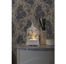 Decoratieve lantaarn met kerstmotief op een commode