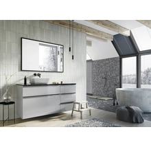 Lichte badkamer met wastafel, spiegel, bad en mozaïektegels op de muur.