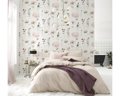 Lichte slaapkamer met bloemetjesbehang, bed en badkuip op de achtergrond