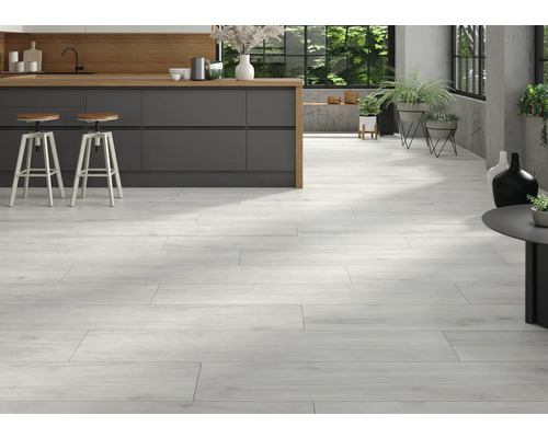 Lichte ruimte met houtlook vloertegels, keukeneiland en barkrukken.