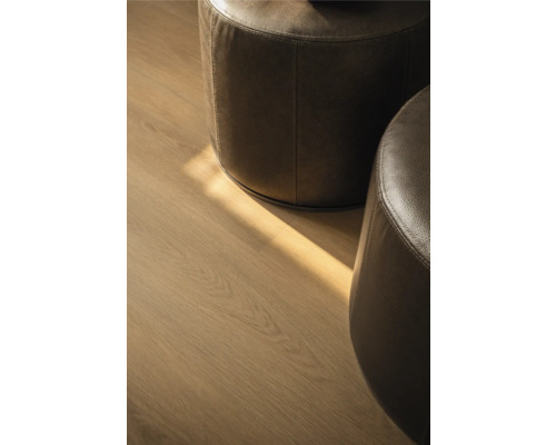 Twee ronde leren poefs op een houten vloer