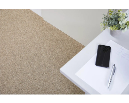 Close-up van een beige tapijtvloer in een lichte kamer.