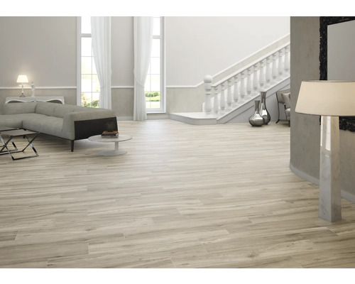 Lichte woonkamer met bank, trap en houtlook tegels