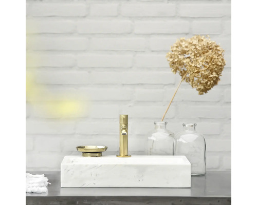 Badkamer wastafel van marmer met gouden kraan en zeepbakje