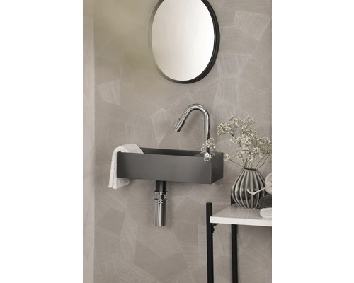 Moderne badkamer met wastafel, kraan en ronde spiegel